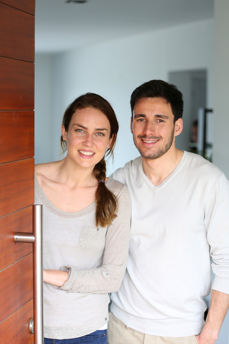 Happy Couple Opening New Home Entrance Door