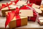 Christmas gift boxes with blank tags on wooden background